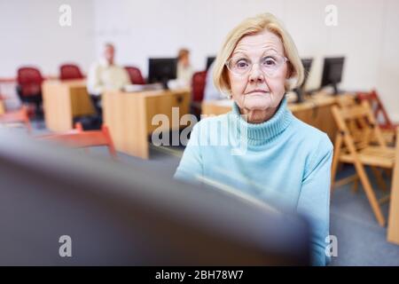 Gli anziani come pensionati imparano a utilizzare Internet su un PC in un corso di informatica Foto Stock