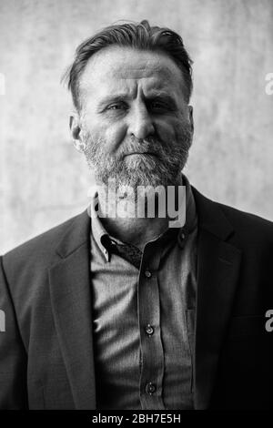 Uomo d'affari maturo, bello e bearded, con tuta in bianco e nero Foto Stock