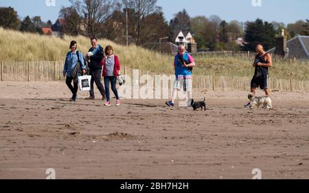 Dundee, Tayside, Scozia, Regno Unito. 24 Aprile 2020. UK Weather: Caldo sole mattina a Dundee anche se un po 'più fresco sulla costa con la temperatura massima 15°C. I proprietari di cani che esercitano i loro cani lungo la spiaggia di Broughy Ferry durante le restrizioni di blocco di Coronavirus. Credit: Dundee Photographics/Alamy Live News Foto Stock