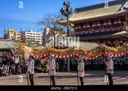 tokyo, giappone - marzo 18 2020: Maestri giapponesi di marionette che tengono un enorme drago d'oro per il tradizionale festival di danza dedicato al bodhisattva Kan Foto Stock