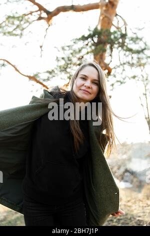 Bella donna in un parco sorridente felice. Giovane donna gioiosa che balla in un parco primaverile Foto Stock