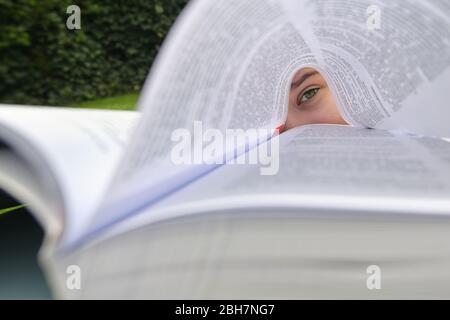 Concetto ragazza che giace in erba e lettura Libro Foto Stock