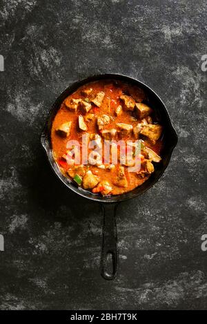 Peri-peri fegatini di pollo in padella su fondo di pietra nera con spazio di testo libero. Vista dall'alto, piatto Foto Stock