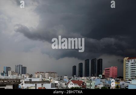 tempesta drammatica con nuvole nere nel cielo sopra l'area urbana con interessante architettura moderna e coloniale Foto Stock