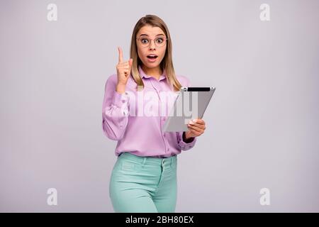 Ritratto di stupito ragazza lavoro tablet pensare pensieri sul progetto impressionato incredibile idea sollevare dito grido womg indossare stile elegante Foto Stock