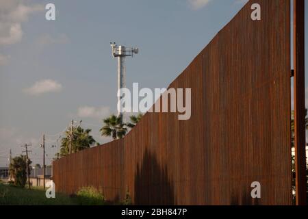 Brownsville Texas USA, 7 ottobre 2009: Una torre della telecamera si trova su una sezione completa del muro di confine alto 20 metri in cemento e acciaio attraverso il centro di Brownsville. Il muro ha lo scopo di rallentare i valichi di frontiera illegali al valico del Rio Grande. ©Bob Daemmrich Foto Stock