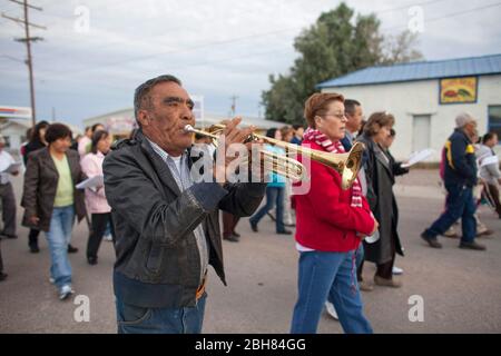 Presidio Texas USA, 9 dicembre 2009: L'uomo suona la tromba come parrocchiani nella chiesa cattolica di Santa Teresa de Jesus nella polverosa città di confine del Texas di Presidio eseguono una posada di Natale o una processione alla chiesa come parte della loro celebrazione di festa della nascita di Cristo. La cerimonia è un mix di ritmi cattolici tradizionali e canti indiani. ©Bob Daemmrich Foto Stock