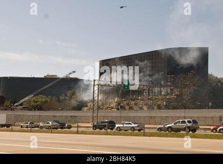 Austin Texas USA, febbraio 18 2010: Il fumo sale dalle macerie dell'edificio degli uffici dopo che Joseph Stack III, un ingegnere software di Austin, ha schiantato il suo aereo privato a motore singolo in un ufficio Internal Revenue Service, uccidendo se stesso e un manager IRS all'interno dell'edificio. Stack, a quanto pare, si è lasciato dietro un manifesto anti-governativo che ha dettagliato i suoi problemi fiscali in corso con l’IRS. ©Marjorie Kamys Cotera/Daemmrich Photography Foto Stock