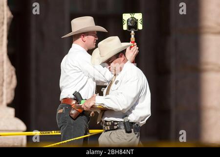 Austin Texas USA, gennaio 21 2010: I Texas Rangers esaminano le prove sui gradini sud del Campidoglio del Texas dopo che un uomo ha sparato parecchi colpi nell'aria là. L'uomo era entrato in precedenza Texas Lt. Gov. L'ufficio del Campidoglio di Dan Patrick ©Bob . Foto Stock