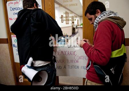 Austin, Texas USA, 4th marzo 2010: Gli attivisti studenteschi dell'Università del Texas protestano contro i tagli proposti ai fondi per l'istruzione superiore che aumenterebbero i costi delle tasse scolastiche e registrerebbero i segnali di protesta sulle porte dell'ufficio di bilancio dell'università.© Marjorie Kamys Cotera/Daemmrich Photos Foto Stock