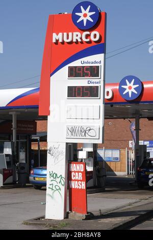 Maypole, Birmingham, West Midlands, Regno Unito. 24 aprile 2020. Una stazione di servizio Murco, definita "la più economica d'Inghilterra", vende benzina senza piombo a soli 95,7 pence al litro. I prezzi bassissimi presso la stazione di servizio di Alcester Road South sono dovuti al calo dei prezzi del petrolio negli Stati Uniti al di sotto dello zero e al calo mensile delle vendite di benzina nel Regno Unito del 18,9%. I clienti hanno fatto la fila per ottenere il carburante dell'affare, poiché il blocco COVID-19 ha colpito duramente i guadagni per molte famiglie. Credito: Interrompi stampa Media/Alamy Live News Foto Stock