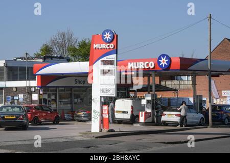 Maypole, Birmingham, West Midlands, Regno Unito. 24 aprile 2020. Una stazione di servizio Murco, definita "la più economica d'Inghilterra", vende benzina senza piombo a soli 95,7 pence al litro. I prezzi bassissimi presso la stazione di servizio di Alcester Road South sono dovuti al calo dei prezzi del petrolio negli Stati Uniti al di sotto dello zero e al calo mensile delle vendite di benzina nel Regno Unito del 18,9%. I clienti hanno fatto la fila per ottenere il carburante dell'affare, poiché il blocco COVID-19 ha colpito duramente i guadagni per molte famiglie. Credito: Interrompi stampa Media/Alamy Live News Foto Stock