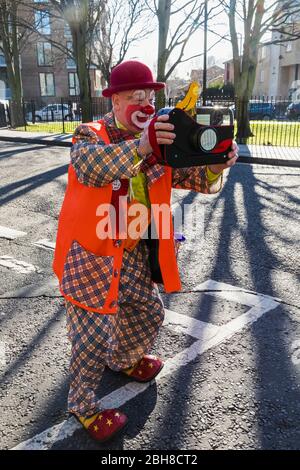 Inghilterra, Londra, l annuale Grimaldi clown servizio di chiesa in chiesa di Tutti i Santi, Haggerston, Clown con fotocamera giocattolo Foto Stock