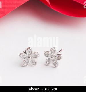 Un paio di splendidi orecchini in argento sterling 925 a forma di fiore decorano con zirconia cubica isolata su sfondo bianco Foto Stock