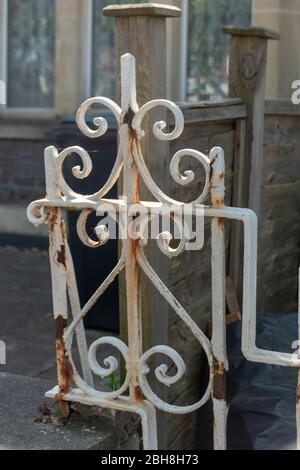 una vista ravvicinata di un vecchio cancello di metallo arrugginito con il peeling bianco Foto Stock