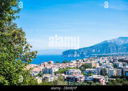 Sopra vista di Sorrento Napoli Campania vacanza bella città luogo. Luogo panoramico mediterraneo con mare blu e alte scogliere montagne. Napoli e Vesuvio sullo sfondo Foto Stock