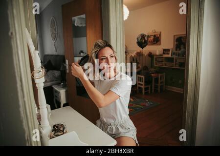 Frau bürstet ihre Haare Foto Stock