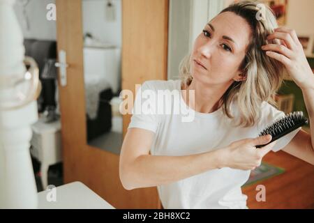 Frau bürstet ihre Haare Foto Stock
