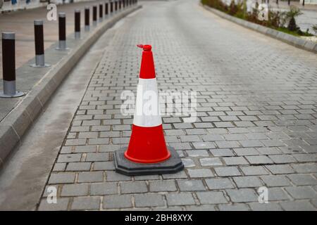 Coni di plastica sulla strada per limitare il trasporto stradale. Cono stradale. Segnale o indicatore di direzione. Sicurezza stradale, spazio copia, messa a fuoco selettiva. Foto Stock