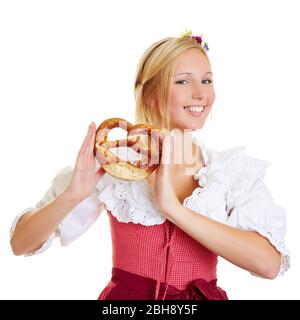 Giovane donna ridente a dirndl con un pretzel Foto Stock