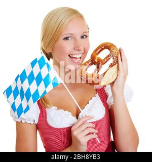 Giovane donna a dirndl con un pretzel e bandiera bavarese Foto Stock