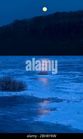 Europa, Deutschland, Hessen, Vöhl, Nationalpark Kellerwald-Edersee, Winterabend am vereisten Edersee, Vollmond, Spiegelung Foto Stock