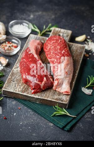 Flap di manzo Fresco crudo Servito con rosmarino, aglio e spezie su tagliatrice di legno. Carne Di Manzo Angus Nera. Primo piano. Foto Stock