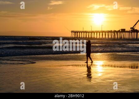 Angler am Strand von Santa Cruz an der Westküste Kaliforniens mit Pier im Hintergrund, Silhouette, Sonnenuntergang Foto Stock