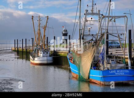 porto sul Mare di Wadden con taglierine di gamberi e faro "Kleiner Preusse", Wremen, località del Mare del Nord, Land Wursten, estuario del Weser, costa del Mare del Nord, bassa Sassonia, Germania del Nord, Germania Foto Stock