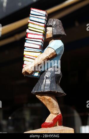 Figura con pila di libri di fronte ad una libreria nella Breite Straße, Città Vecchia, Buxtehude, Altes Land, bassa Sassonia, Germania, Europa Foto Stock