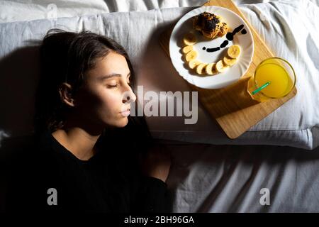 Donna che dorme con colazione a letto. Foto Stock