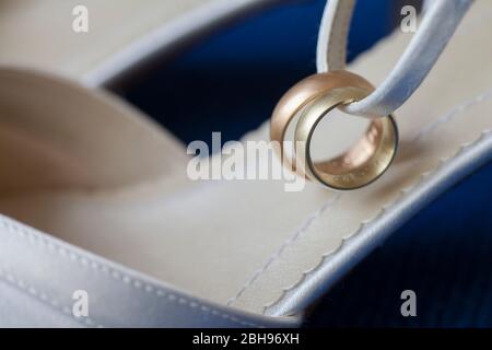 Anelli per matrimoni in oro e oro rosso a scarpe da sposa bianche Foto Stock