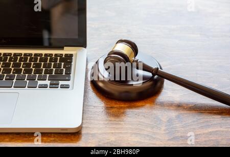 Asta legge gavel e un computer portatile, sfondo ufficio in legno, vista primo piano, asta online, cyber crimine concetto Foto Stock