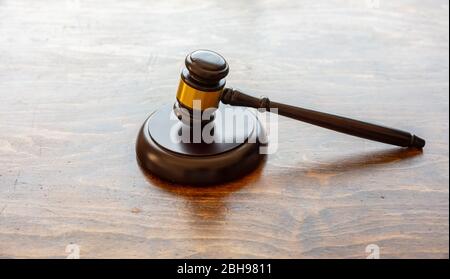 Tema della legge. Giudicate il gavel sullo sfondo del banco ufficio in legno, vista ravvicinata. Asta, tavolo da tribunale Foto Stock