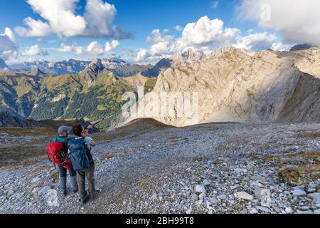 Due escursionisti osservano il gruppo Sella e il gruppo Marmolada dell'Alto Sentiero Bepi Zac, il crinale Costabella, il gruppo Marmolada, le Dolomiti, la Val di Fassa, la provincia di Trento, il Trentino-Alto Adige, Italia Foto Stock