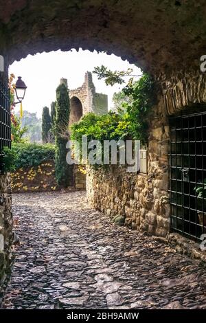 Volta in pietra che si affaccia Torre de les Hores di fronte a Peratallada in autunno Foto Stock