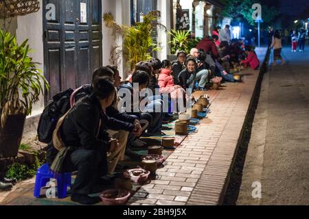 Laos, Luang Prabang, Tak Bat, processione all'alba di monaci buddisti collezionando elemosine, spettatori, senza rilasci Foto Stock