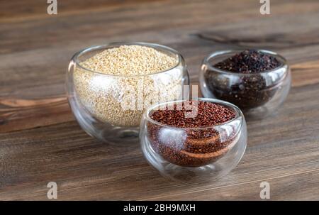 Diversi tipi di quinoa su sfondo di legno Foto Stock