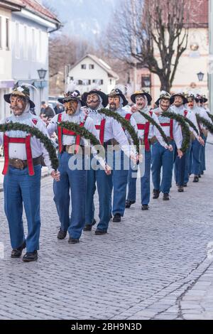 Agitatori a pinza con maschere in larve di legno a Murnau gettano fuori l'inverno, Domenica di Carnevale Foto Stock