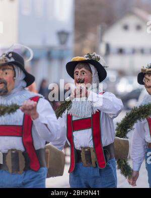 Agitatori a pinza con maschere in larve di legno a Murnau gettano fuori l'inverno, Domenica di Carnevale Foto Stock