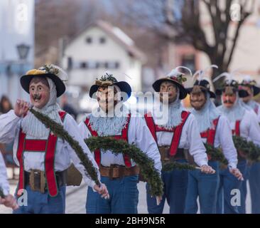 Agitatori a pinza con maschere in larve di legno a Murnau gettano fuori l'inverno, Domenica di Carnevale Foto Stock