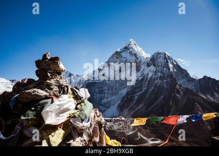 Cairn con bandiere di preghiera sullo sfondo Ama Dablam Foto Stock