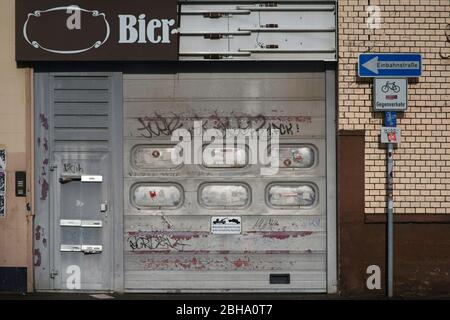 Un ingresso di casa con una porta di metallo e una posizione abbassata di garage tapparella come pure un nostalgico segno di birra. Foto Stock