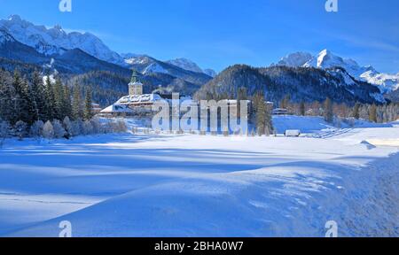 Castello Elmau contro Wetterstein e Monti Karwendel in inverno, Elmau, vicino Klais, Werdenfelser Land, alta Baviera, Baviera, Germania Foto Stock