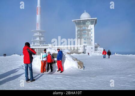 Escursionista alla casa sommitale con hotel e radio mast in inverno, a Brocken, Wernigerode, Harz Nature Park, Sassonia-Anhalt, Germania Foto Stock