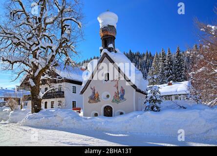 Winterly cappella innevata con muro Painting a Klais, vicino Mittenwald, Werdenfelser Land, alta Baviera, Germania Foto Stock