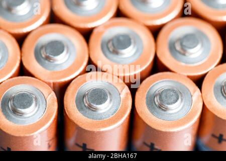 Primo piano delle estremità positive delle celle della batteria a file, vista dall'alto, messa a fuoco morbida. Batterie alcaline AA usate. Foto Stock