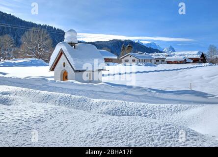 Cappella coperta di neve nella frazione di Gerold vicino a Klais, vicino Mittenwald, Werdenfelser Land, alta Baviera, Germania Foto Stock