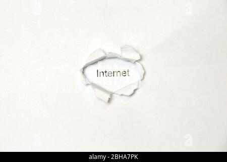 Parola internet su sfondo bianco isolato, l'iscrizione attraverso il foro avvolto nella carta. Foto di scorta per il Web e stampa con spazio vuoto per testo e design. Foto Stock