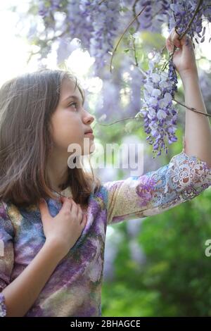 Ragazza nel parco vicino Wisteria Foto Stock